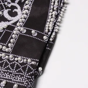 Detail shot showing exquisite white pearl beads and pattern on court-style blazer.