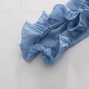 Macro detail of elegant light blue ruffled hem with pleated texture on summer resort top