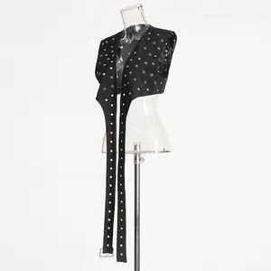Detailansicht einer schwarzen ärmellosen Punk-Weste mit Metallösen und langen Riemen