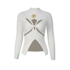 Détail du haut en tricot côtelé blanc avec découpe torsadée et broche en forme d'œil en métal