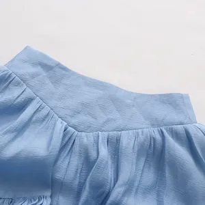 Close-up of light blue crinkled fabric with elegant ruffle detail on a summer top
