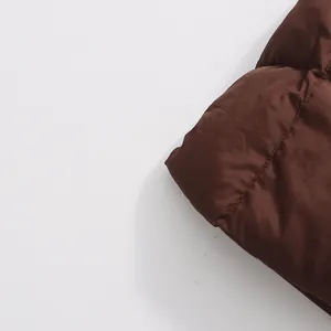 Detalle de primer plano de abrigo acolchado marrón con textura de tela y costuras