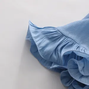 Close-up macro shot of light blue ruffle detailing and textured fabric on a resort set