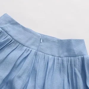 Detailed macro shot of light blue summer skirt waist showing hidden zipper and pleated fabric texture