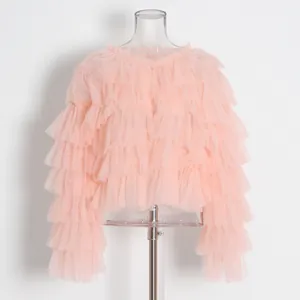 Vista detallada de los volantes de tul rosa en capas de esta blusa holgada de verano.