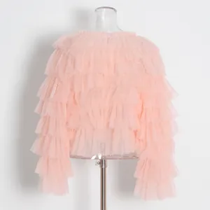 Vista trasera detallada de un top de malla rosa con capas de volantes y diseño vaporoso