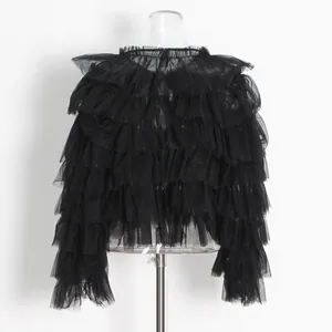 Detalle de los volantes de malla negra escalonados del top gótico dulce y holgado en un maniquí.