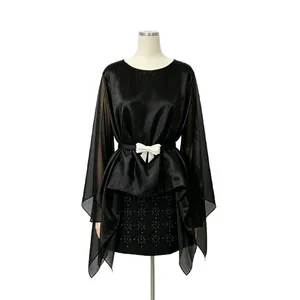 Vista dettagliata di una blusa nera in chiffon con cintura a fiocco e maniche a mantella