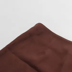 Close-up detail of the waist of a dark brown pencil skirt with smooth fabric texture