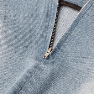 Primer plano del detalle de la cremallera metálica en minifalda vaquera azul claro