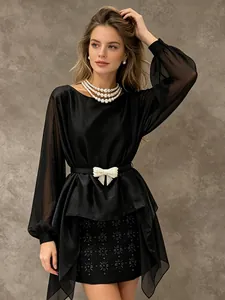 Elegante camicetta francese in chiffon nero con maniche lunghe, vita a fiocco e orlo irregolare.