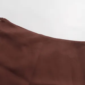 Detailed view of the invisible side zipper and waistline on elegant brown midi skirt