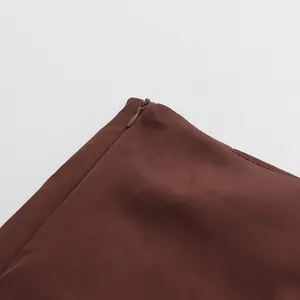 Close-up detail of a seamless invisible side zipper on an elegant brown pencil skirt