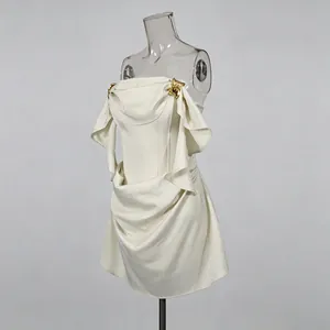 Detail van luxe strapless satijnen mini-jurk met gedrapeerde hals en metalen gespen.