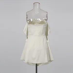 Gedetailleerd achteraanzicht van een witte satijnen strapless mini-jurk met ruches
