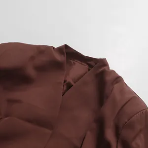 Close-up detail of the elegant brown V-neckline on a silky satin suit jacket