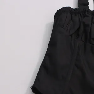 Close-up of black camisole top featuring ruched elastic waist and structural seams