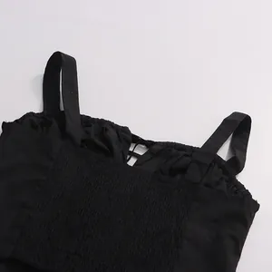 Detailed macro shot of the smocked elastic back panel on a stylish black camisole top