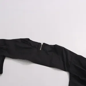 Close-up view of a black summer shrug top featuring a functional back silver zipper detail