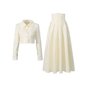 Close-up of elegant two-piece set with pearl-embellished jacket and pleated skirt