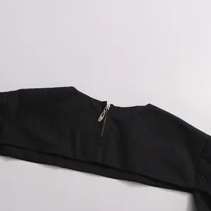 Close-up of elegant black puff sleeve shrug showing the silver back zipper detail