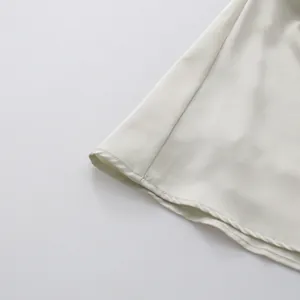 Detailopname van de gladde satijnen zoom met fijne stiksels en zachte val