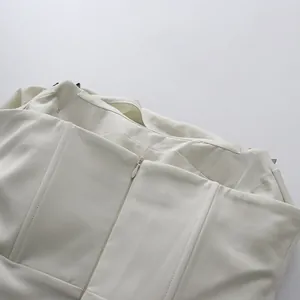 Detail van de onzichtbare ritssluiting op de rug van een crème satijnen gala-jurk.