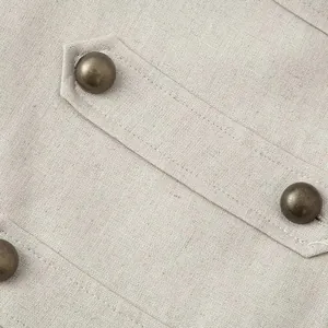 Detail view of apricot linen vest dress showing vintage metal buttons and fabric texture.