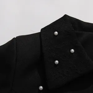 Close-up of elegant black French vintage top with lace collar and pearl buttons