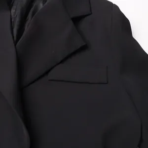 Nahaufnahme des Revers und der Pattentasche an einem taillierten schwarzen Blazer-Kleid