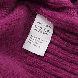 Detailed close-up showing the white care label on a purple knitted polyester fabric