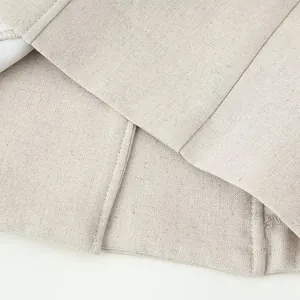 Detailed macro view of high-quality apricot linen fabric texture and precise garment stitching