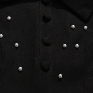 Detail view showing white pearls and fabric buttons on black vintage French style top
