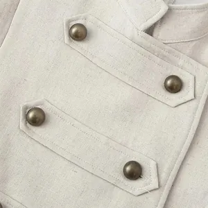 Close-up detail of apricot sleeveless dress featuring vintage bronze buttons and linen texture