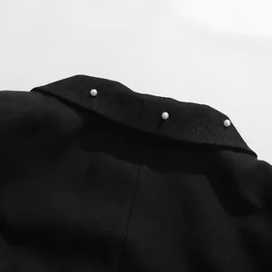 Close-up detail of black vintage French style top collar with elegant white pearls.