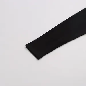 Vista ravvicinata del dettaglio del polsino su una maglietta nera a maniche lunghe minimalista.