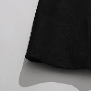 Close-up detail of the premium black fabric texture and hemline of a vintage skirt set