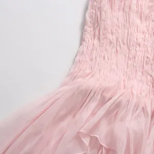 Vista dettagliata della texture elasticizzata rosa e dell'orlo con volant di un top