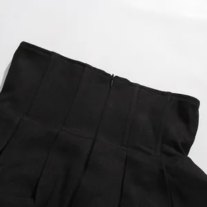 Close-up of black high-waisted skirt featuring a concealed zipper and vertical seams.