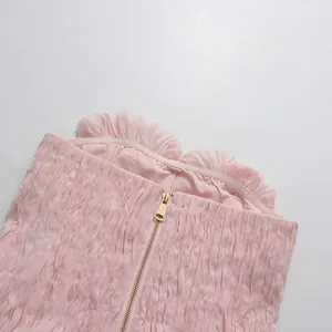 Dettaglio di un top a fascia rosa con volant e cerniera posteriore in metallo dorato