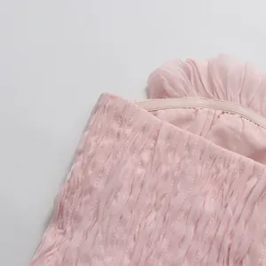 Dettaglio macro del top a fascia rosa con volant che mostra il tessuto testurizzato e la striscia