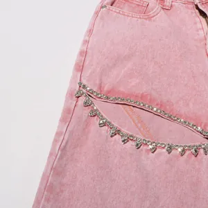 Vue détaillée d'un jean rose avec garniture en strass et découpe design tendance.