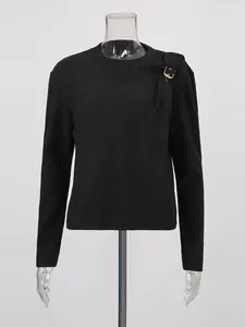 Maglia nera a maniche lunghe con fibbia decorativa in metallo dorato sulla spalla sinistra.