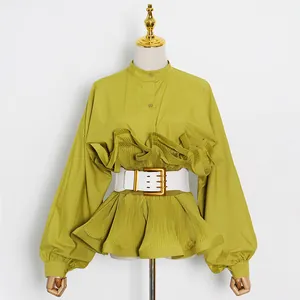 Detail view of a stylish lime green ruffled shirt featuring a white wide belt and mandarin collar