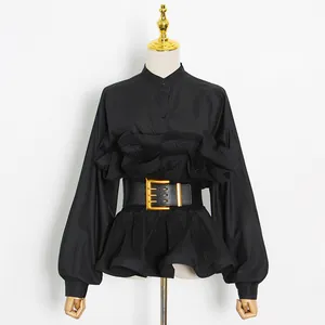 Elegant black ruffle shirt with stand collar and wide belt on mannequin detail.