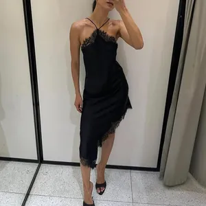 Detailed full view of an elegant black halter neck dress with lace and asymmetric hem