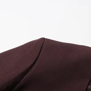 Close-up macro detail of the shoulder seam and smooth fabric texture of a maroon blazer.