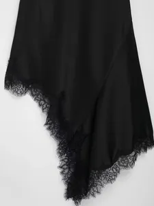 Detailed view of exquisite black eyelash lace hem on a silky irregular satin dress