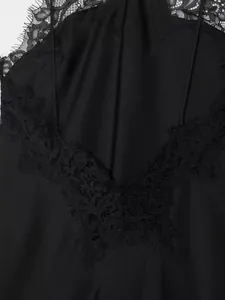 Detailed macro shot of black silk dress featuring delicate eyelash lace trim edge