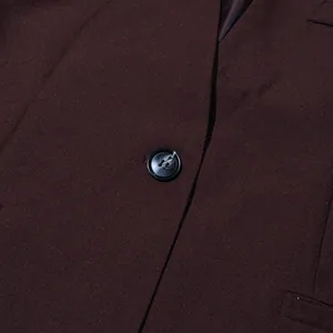 Detailed close-up showing the single button of a dark brown tailored blazer jacket